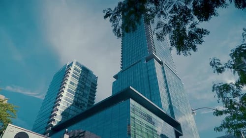 Mirrored Office Tower in the Middle of the City on a clear blue day with slow pan down to street lev
