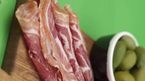 Vertical video, Close-up: cold cuts, salami, prosciutto, jamon, cherry tomatoes, sliced sausage