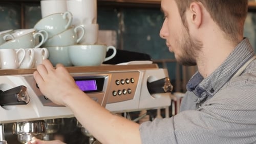 Young Adult Barista Makes Espresso Drinks Professionally