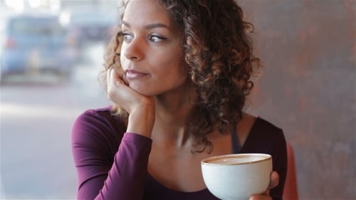 Woman Enjoys Coffee and Dessert Inside Cafe