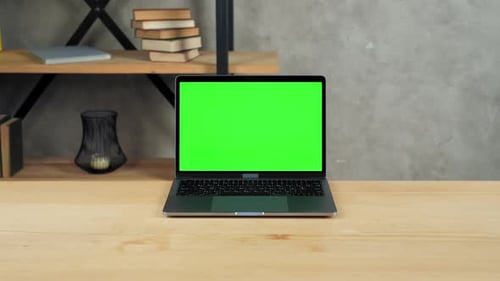 Modern laptop computer display with mock up chroma key green screen on table