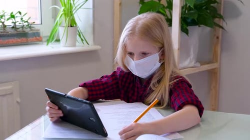 Girl Wearing Mask Does Homework on Tablet