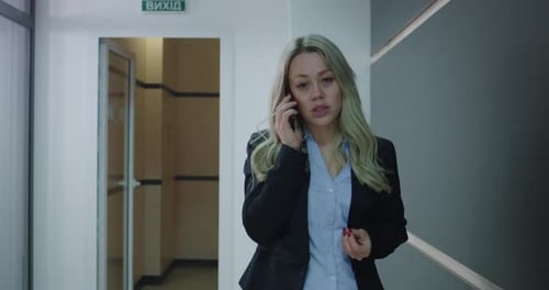 Business Woman Phoning in Office Corridor
