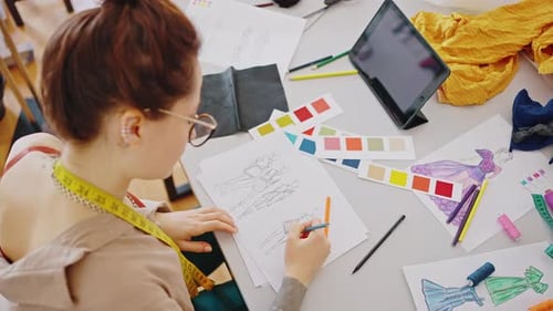 Top View of Lady Designer Creating New Clothes Collection Sitting with Color Swatches and Coloring