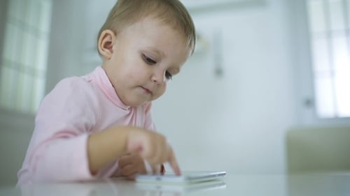 Baby Uses Tablet Device at Table Indoors