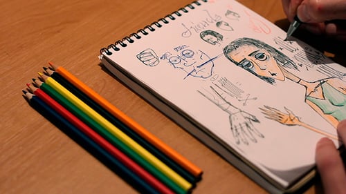 Artist Drawing Cartoon Characters in Sketchbook