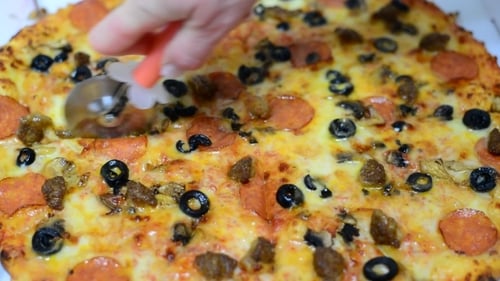 Cutting Delicious Pizza with Cutter into Slices