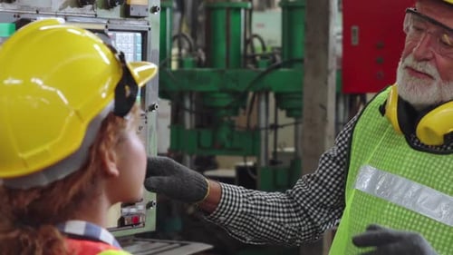 Groupe d'ouvriers d'usine utilisant des équipements mécaniques dans un atelier d'usine