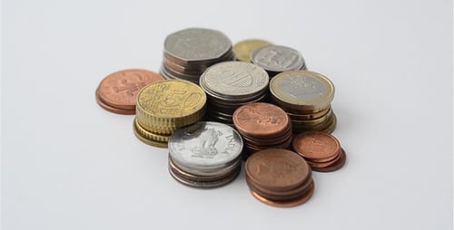 Collection of international metal coins stacked in piles