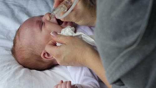 Mère à l'aide d'un aspirateur nasal bébé aspiration de mucus