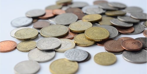 Assorted Foreign Coins Piled on White Surface