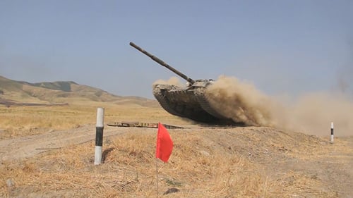 Powerful Tank Driving Through Arid Rural Landscape