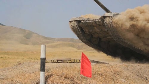 Military Tank Moving Fast on a Rural Field