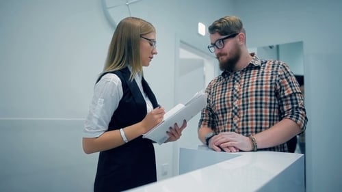 Woman Helping Client at Modern Reception Desk