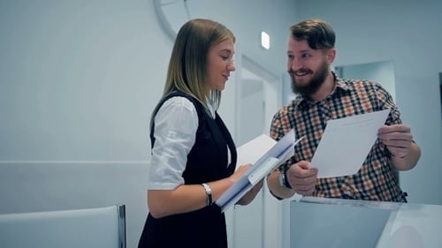 Professionals Reviewing Documents at Office Reception Desk