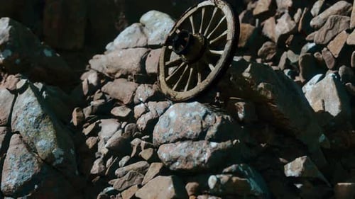 Weathered Wooden Wagon Wheel on Rocky Terrain