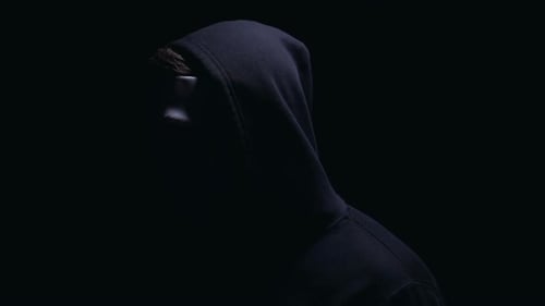 Erschreckender Mann in Maske, der plötzlich aus der Dunkelheit auftaucht, Cyberangriff, Nahaufnahme