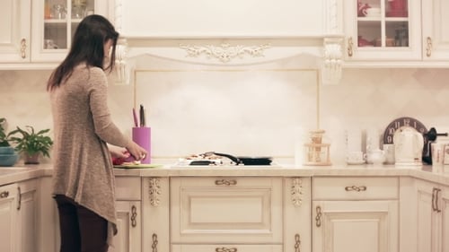 Woman Chopping Vegetables in a Kitchen