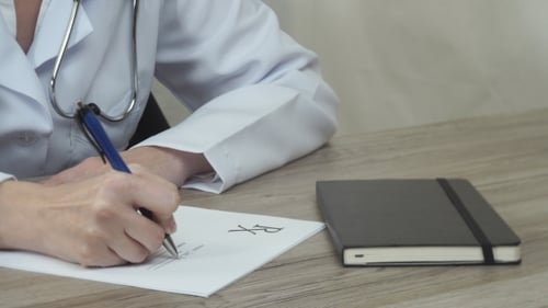 Doctor Writes Prescription in Clinic Room