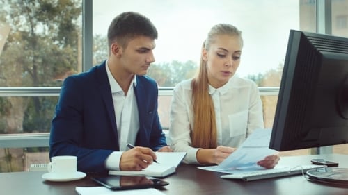 Young Professionals Collaborate on Business Charts in Office