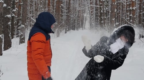 Couple In The Park In Winter Throws Snow Up