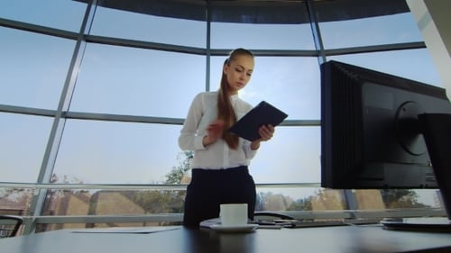Attractive Girl With Tablet Works In The Office