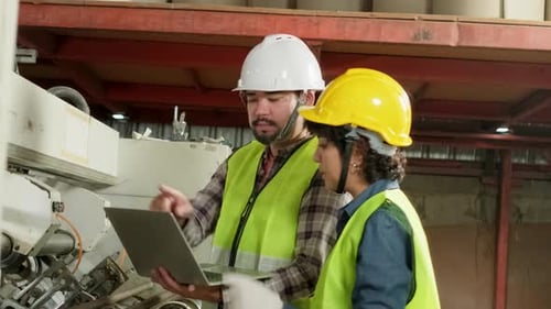 Factory Workers Inspect Machine with Laptop Computer