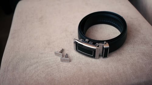 Zubehör: Auf einem Stuhl liegender Bräutigam, Manschettenknöpfe und Gürtel