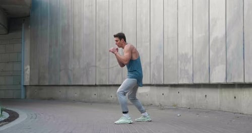 Young Adult Man Boxing Outdoors in Urban Setting