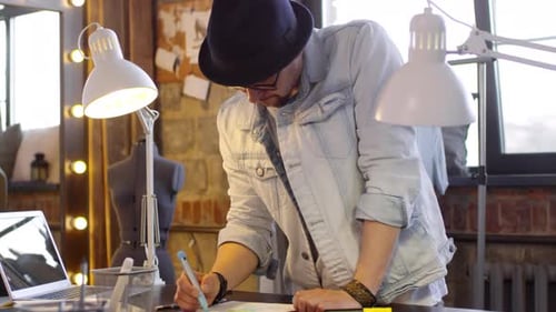 Male Fashion Designer Drawing Dress in Sewing Studio