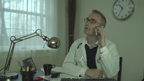 Arzt arbeitet an seinem Schreibtisch 16