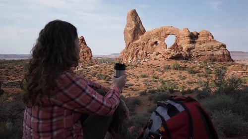 Kranaufnahme einer Frau, die Wasser im Arches-Nationalpark trinkt 1