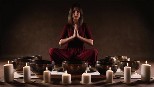 Woman Playing Tibetan Singing Bowls with Candles