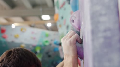 Slow Motion of Skilled Male Climber Climbing Up Wall in Gym Indoors Training Alone