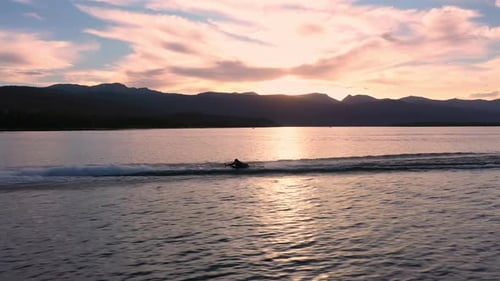Aerial view of people playing on lake as a watercraft pulls and whips person around