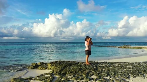 Girl happy and smiling on beautiful tourist beach adventure by aqua blue sea with white sandy backgr