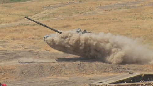 Tank Drives Through Field Crushing Markers