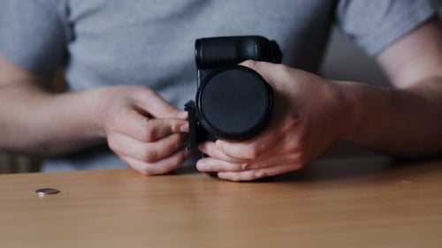 Man Fastens To The Camera Tripod Base