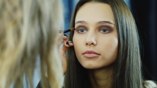 Junge Frau schminkt sich um die Augen