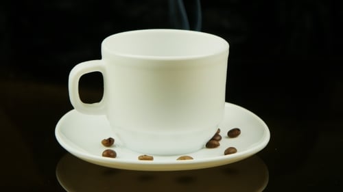 Steaming Cup of Coffee with Coffee Beans