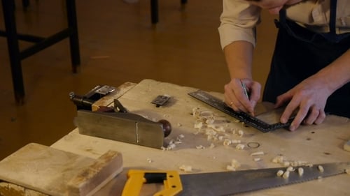 Man Marking Wood Block with Ruler in Workshop