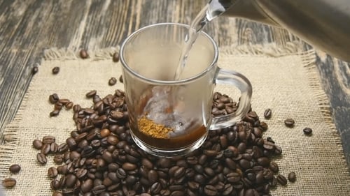 Pouring Hot Water Into Coffee Mug With Beans