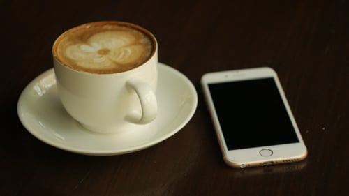 Latte and Smart Phone on Wooden Table