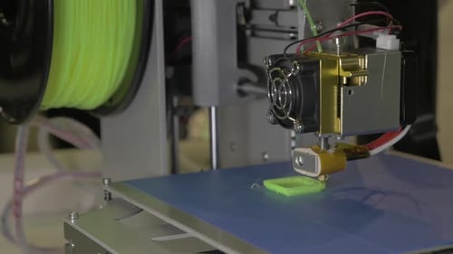 3D-Drucker in Bearbeitung. Es stellt Teile für Ausrüstung aus grünem Kunststoff
her
