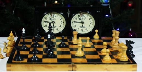 Chess Match with Christmas Decorations in Background