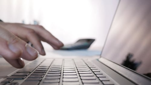 Hands Typing on Laptop Keyboard at Desk