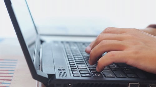 Hands Typing on Laptop at Workplace