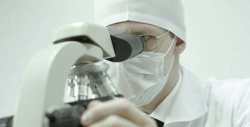 Physician Looks Through a Microscope