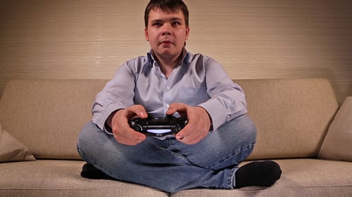 Young Adult Gamer Playing Video Game on Couch
