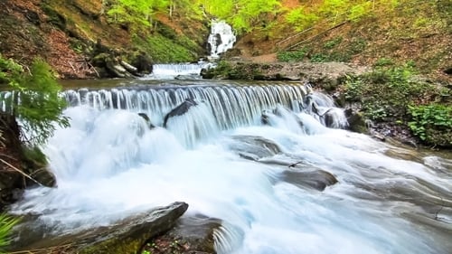 Picturesque Waterfall Flowing Through Lush Green Forest